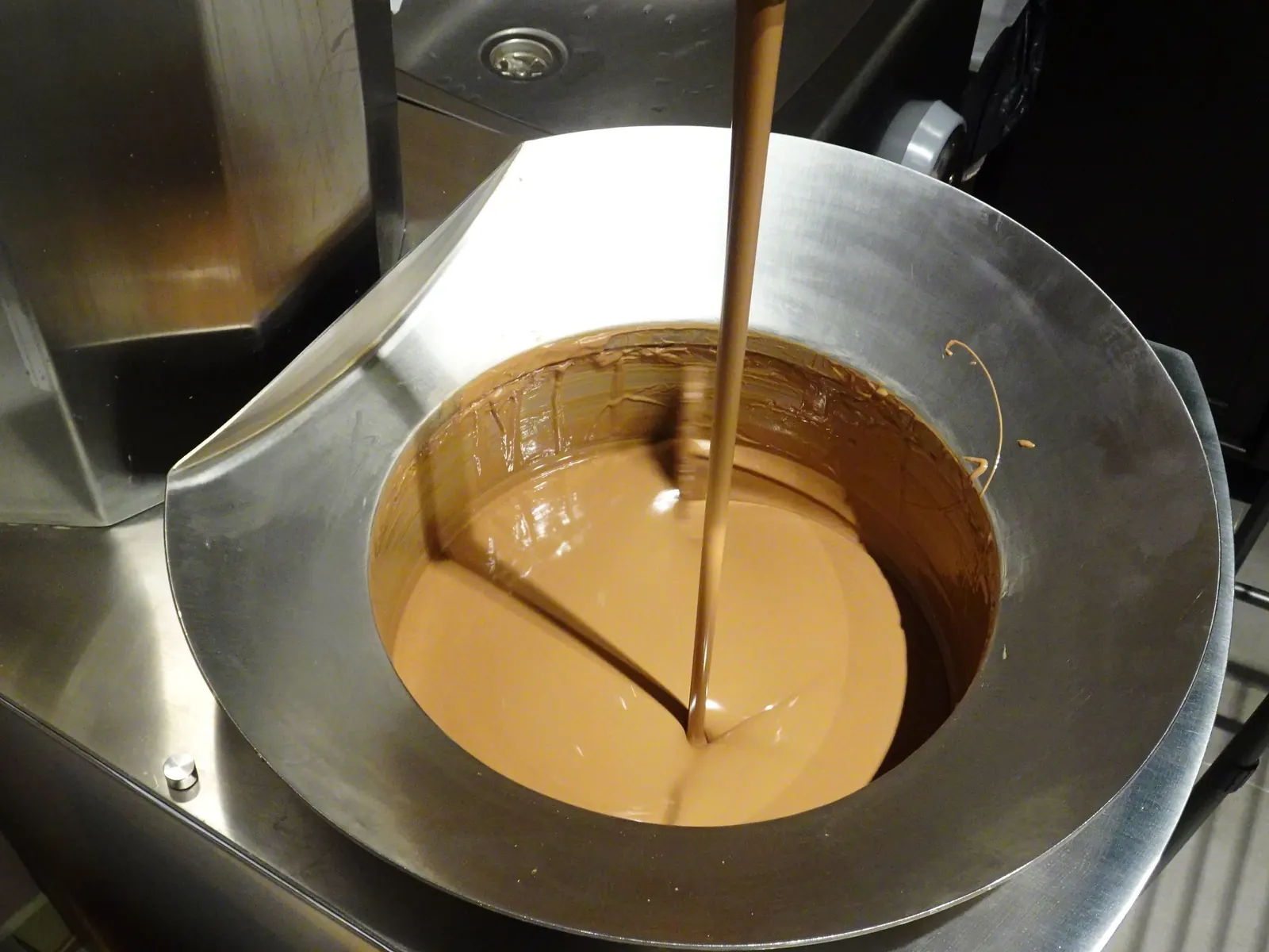 Chocolat fondu coulant dans une cuve de travail en acier à la Città del Cioccolato de Pérouse