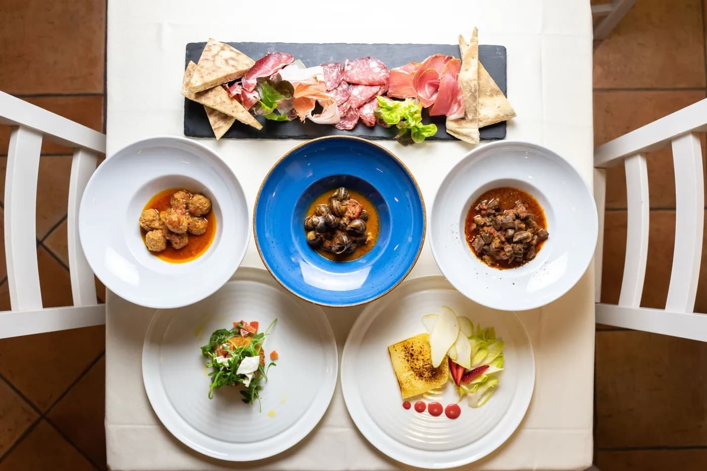 Ein Tisch im Ristorante Carfagna von oben, mit Wurstplatte, Vorspeisen und warmen Gerichten