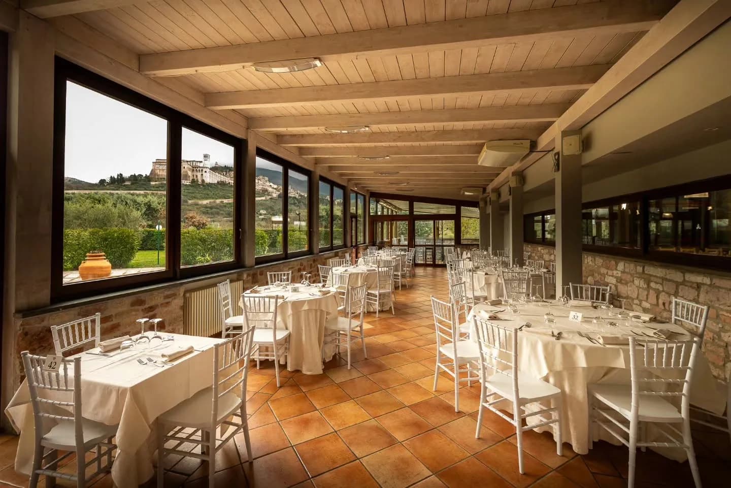 Speisesaal des Ristorante Carfagna mit großen Fenstern mit Blick auf Assisi