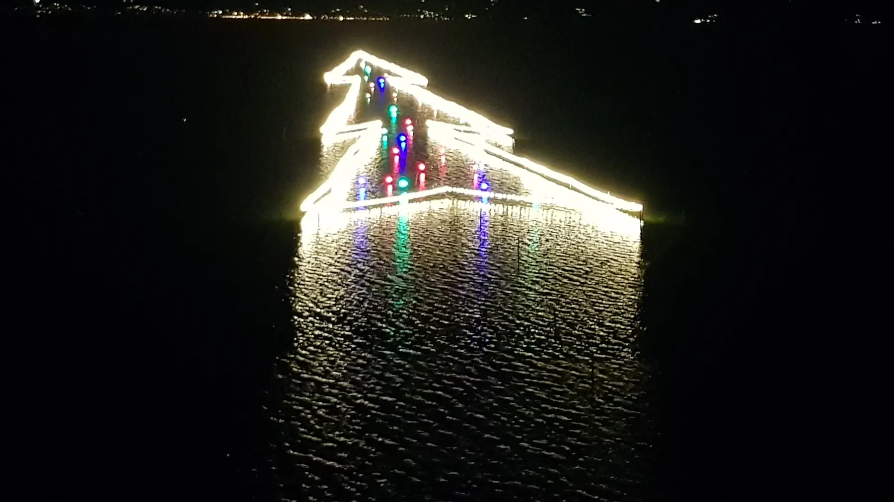 L'albero di Natale di luci disegnato sull'acqua del lago Trasimeno a Castiglione del Lago, di notte