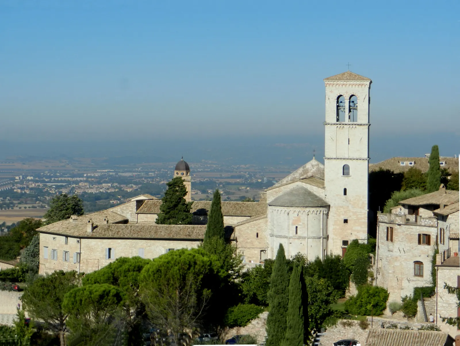 Santa Maria Maggiore e il suo campanile tra le case di Assisi, con la valle sullo sfondo