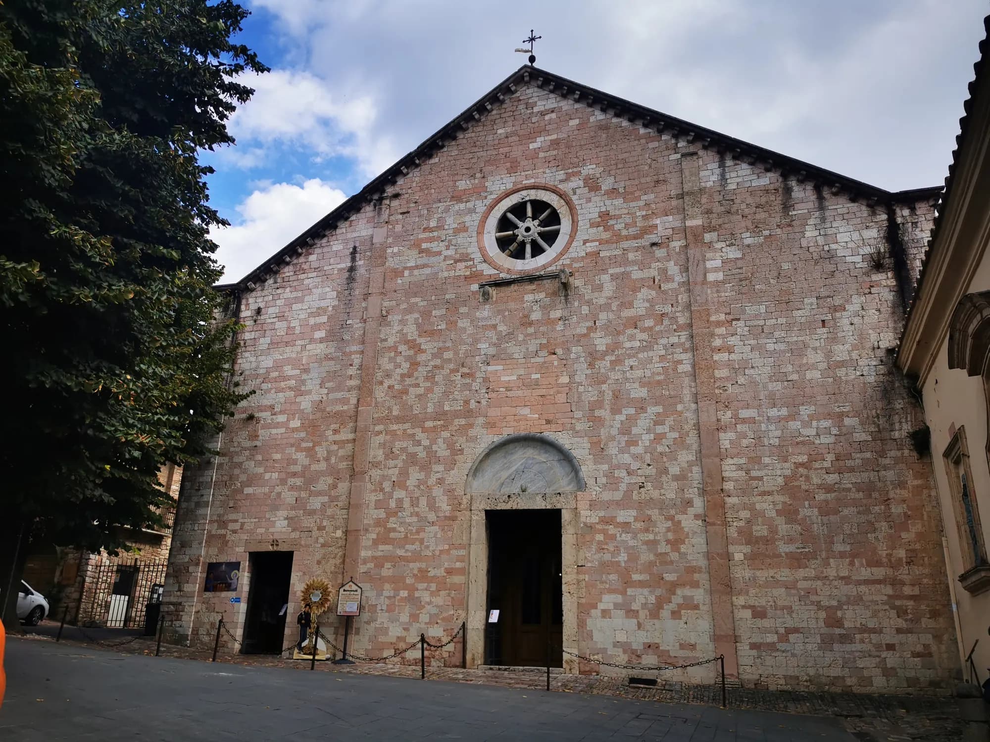 Steinfassade der Kirche Santa Maria Maggiore in Assisi, Sitz des Heiligtums der Entkleidung, mit Fensterrose