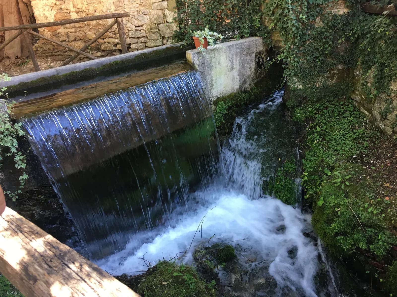 A small waterfall flowing over stones and moss in Rasiglia